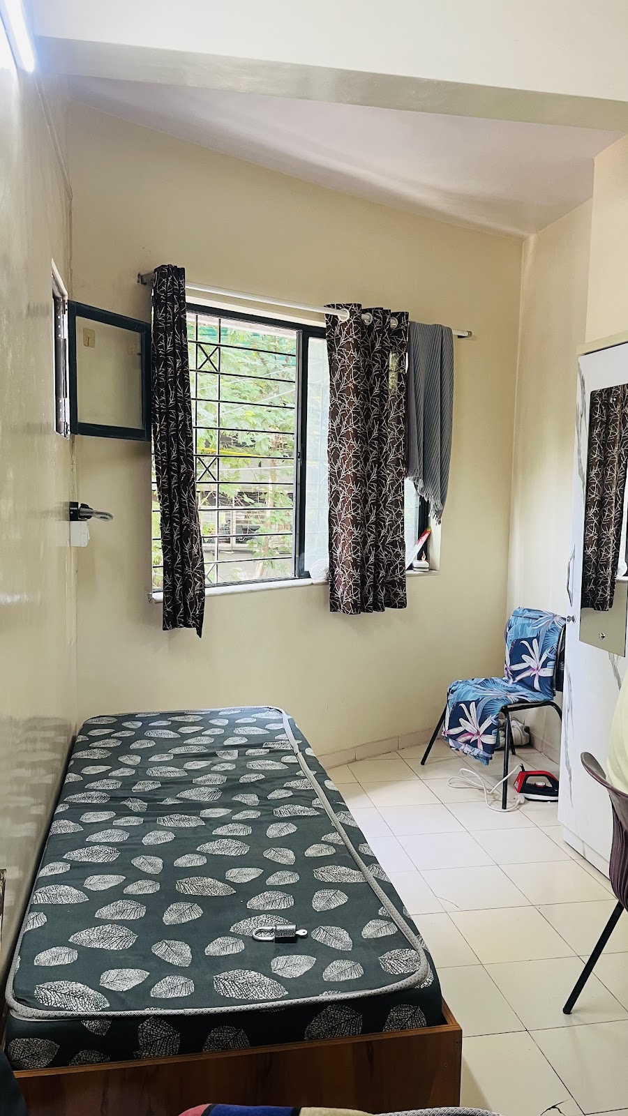 Single Cot by Window with Green Patterned Mattress & Chair